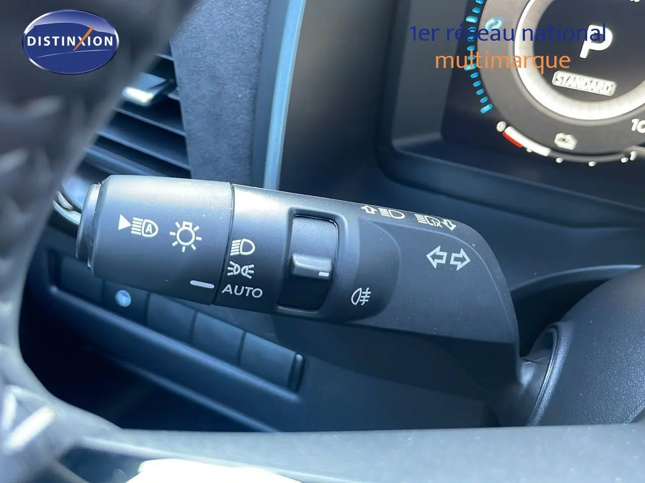 Gros plan sur la commande des feux et clignotants à gauche du volant du Nissan Qashqai 2025 gris céramique.