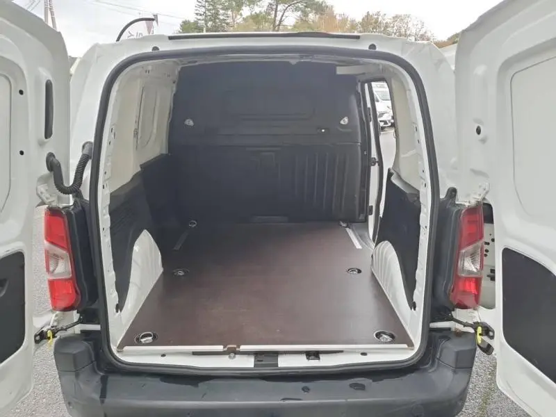 Vue arrière ouverte du Peugeot Partner blanc 2019 montrant l'espace de chargement avec plancher bois antidérapant.