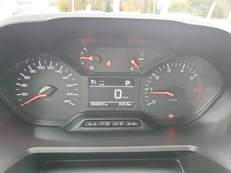 Tableau de bord du Peugeot Partner 2019 montrant les compteurs et l'écran digital au centre en vue frontale.