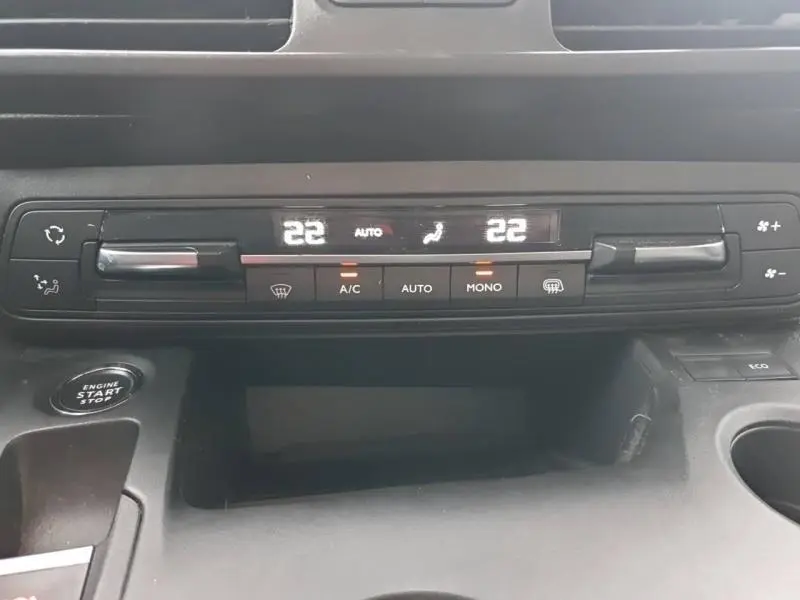 Tableau de bord du Peugeot Partner 2019 montrant la climatisation automatique bizone avec affichage digital et bouton start-stop.