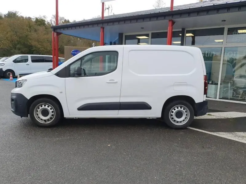 Profil côté gauche d'un utilitaire Peugeot Partner blanc banquise avec portes latérales et enjoliveurs acier.