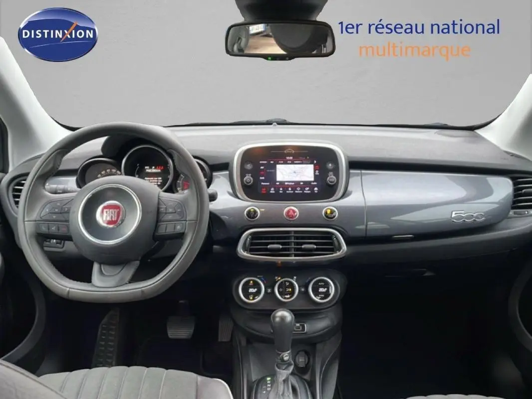 Intérieur de Fiat 500X gris foncé, vue frontale du tableau de bord avec volant multifonction et écran tactile central.