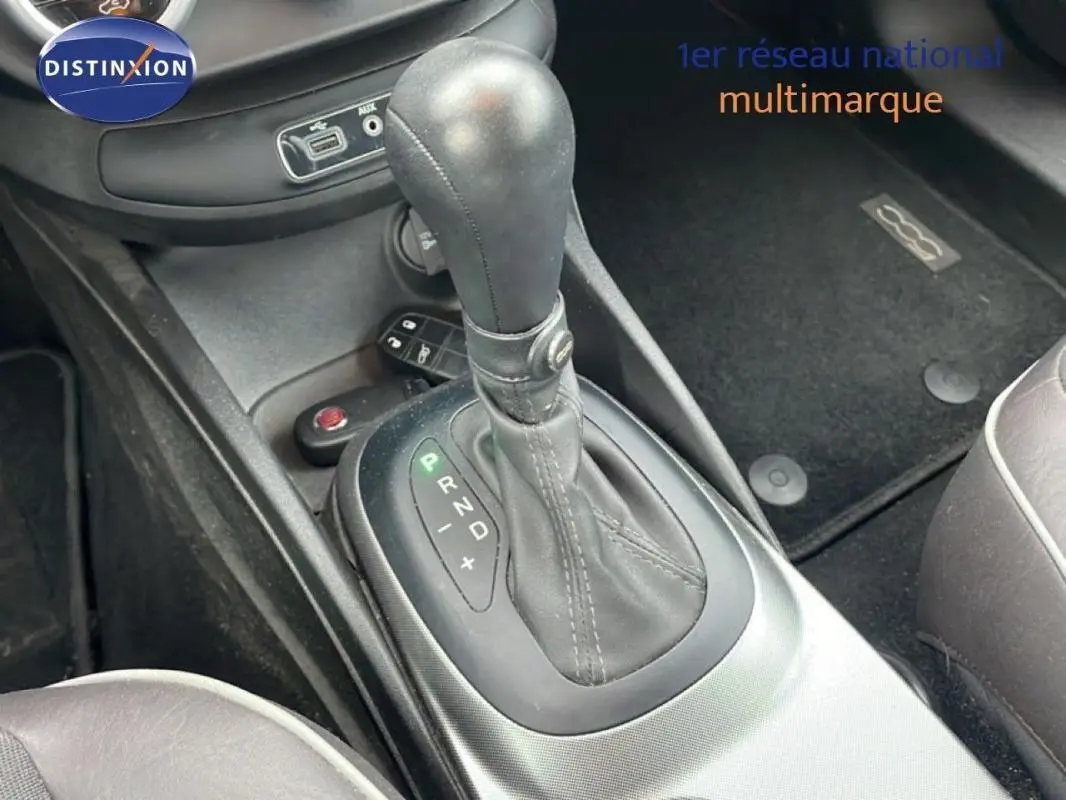 Le levier de vitesse automatique en cuir noir de la FIAT 500X MY18 gris foncé, vue intérieure centrée sur la console centrale.