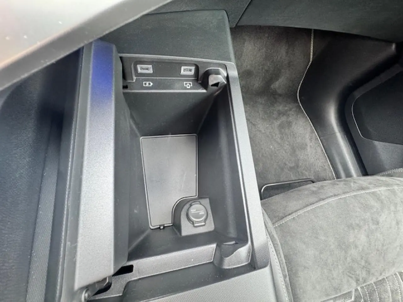 Vue rapprochée de la console centrale intérieure du Peugeot 3008 II gris, montrant prises USB et prise 12V.