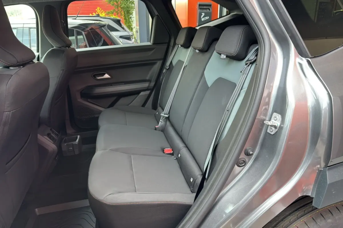 Vue intérieure côté droit montrant la banquette arrière grise du Dacia Bigster Hybrid 155 Extreme Plus avec portières ouvertes.