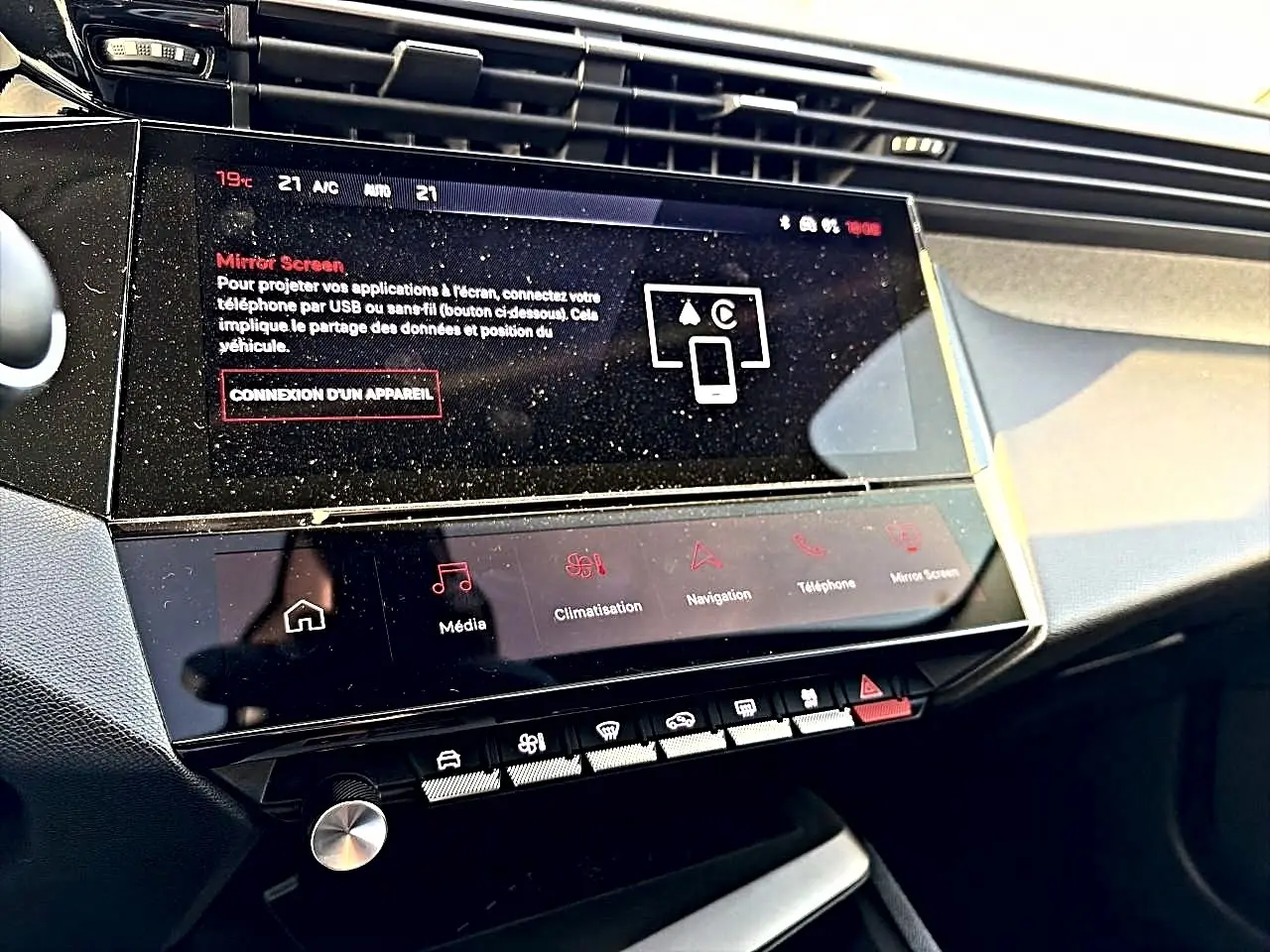 Vue rapprochée de la console centrale noire de la Peugeot 408 Hybrid 145 avec écran tactile et commandes tactiles.