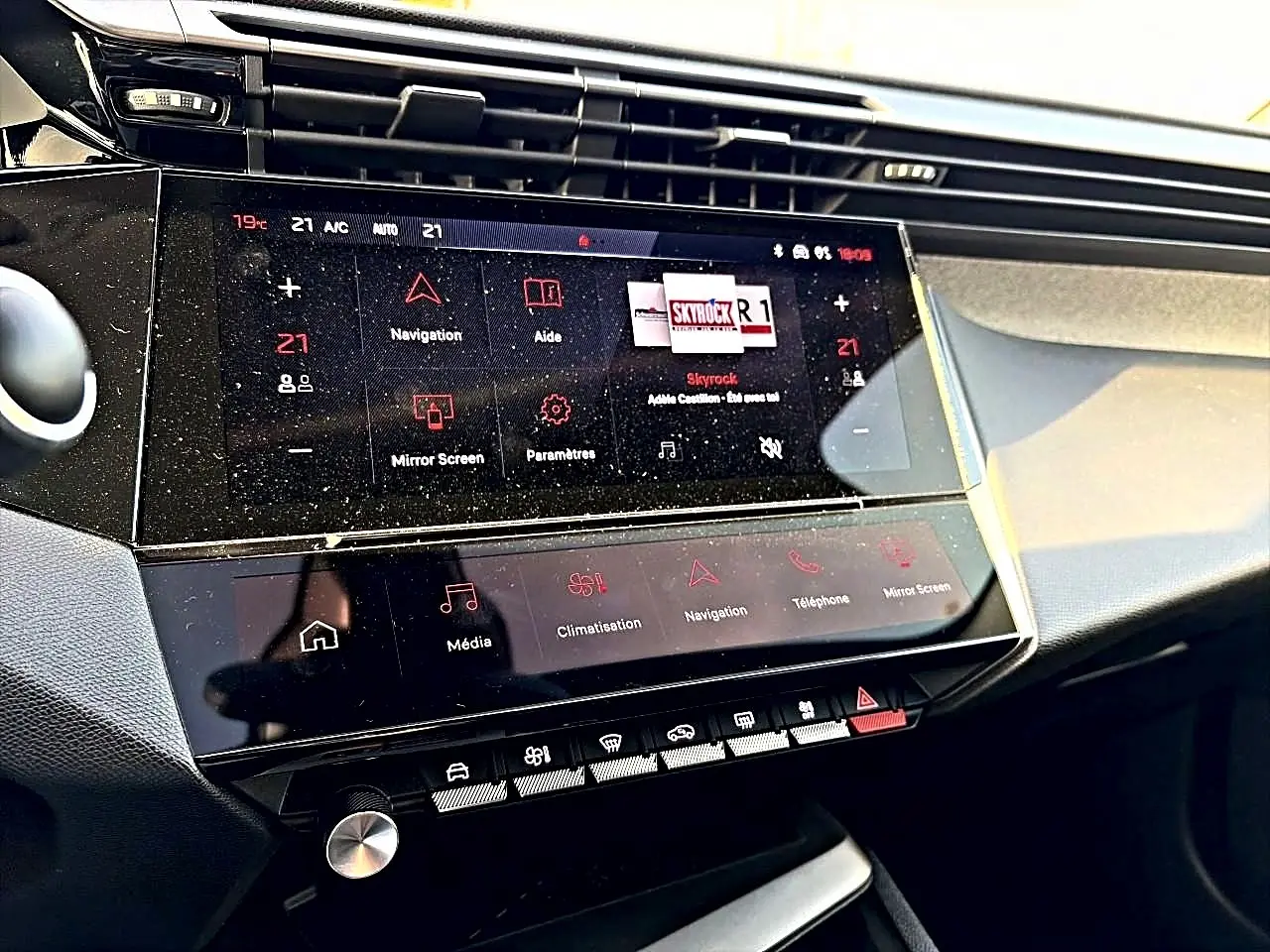 Vue rapprochée de la console centrale tactile du Peugeot 408 Hybrid 145 allure noir, affichant les commandes multimédia et climatisation.