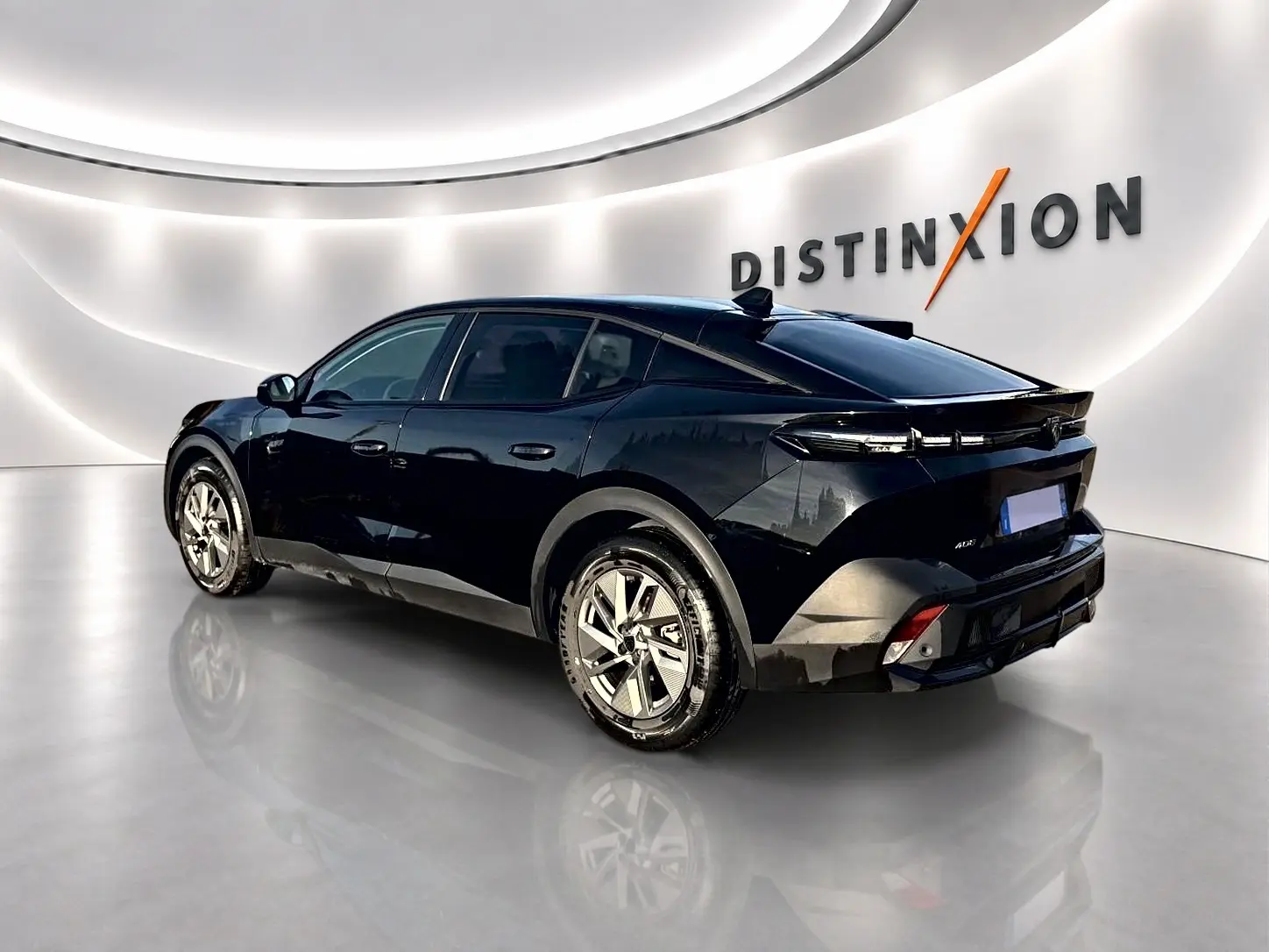Peugeot 408 Hybrid noir vue 3/4 arrière droit dans un showroom avec jantes alu et vitres teintées.