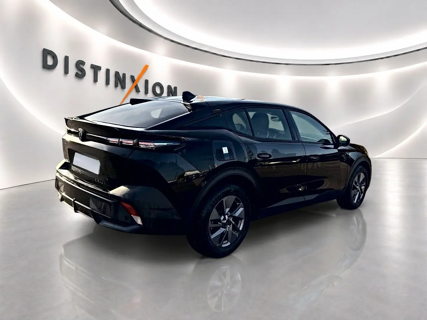 Peugeot 408 Hybrid 145 allure noir vue 3/4 arrière droit dans un showroom lumineux avec jantes alu.