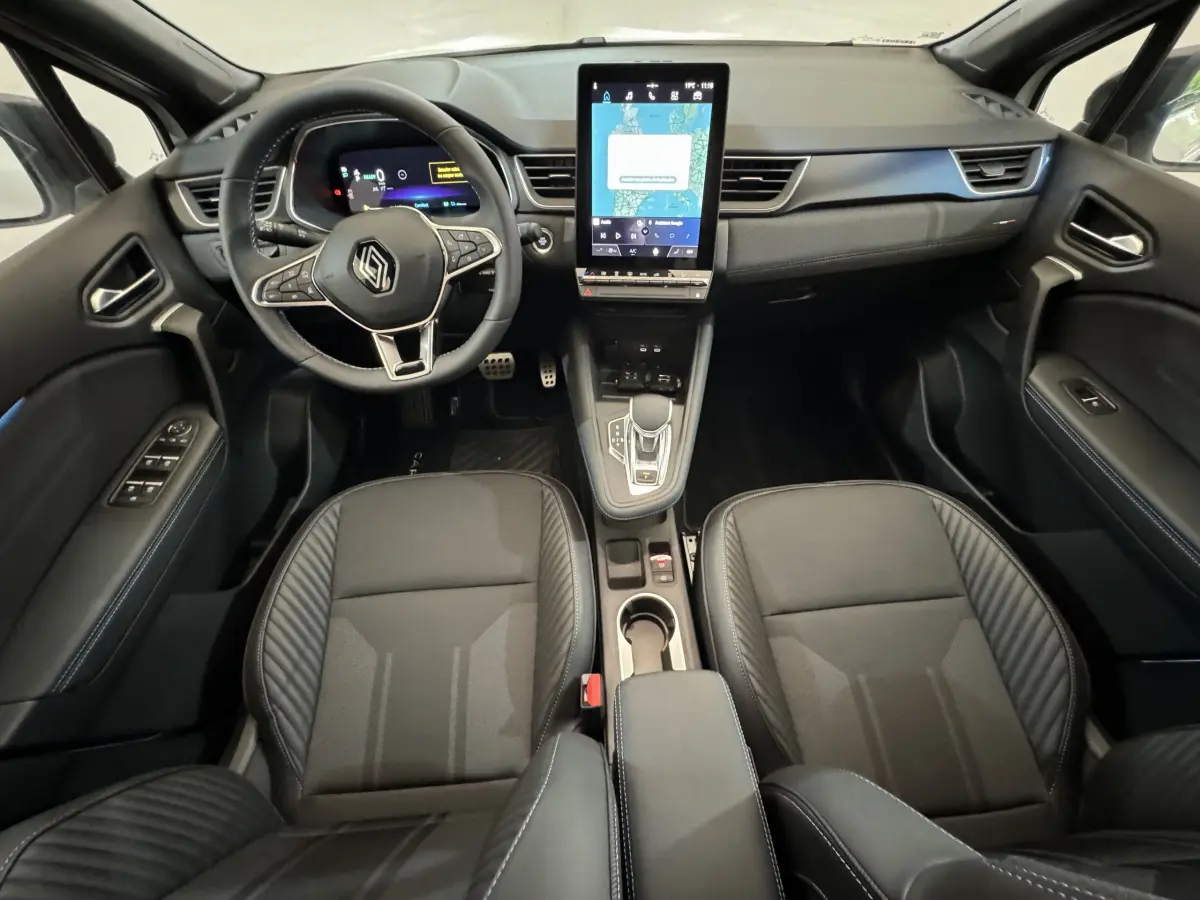 Intérieur noir du Renault Captur Esprit Alpine E-Tech 2025 vu de face, avec écran tactile vertical central et volant multifonctions.