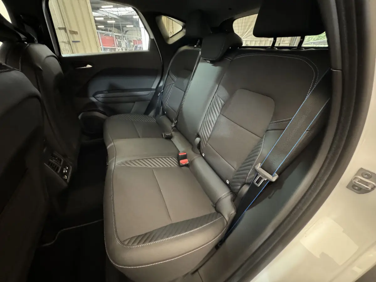 Banquette arrière noire avec surpiqûres bleues dans un Renault Captur blanc, vue côté droit arrière ouvert.