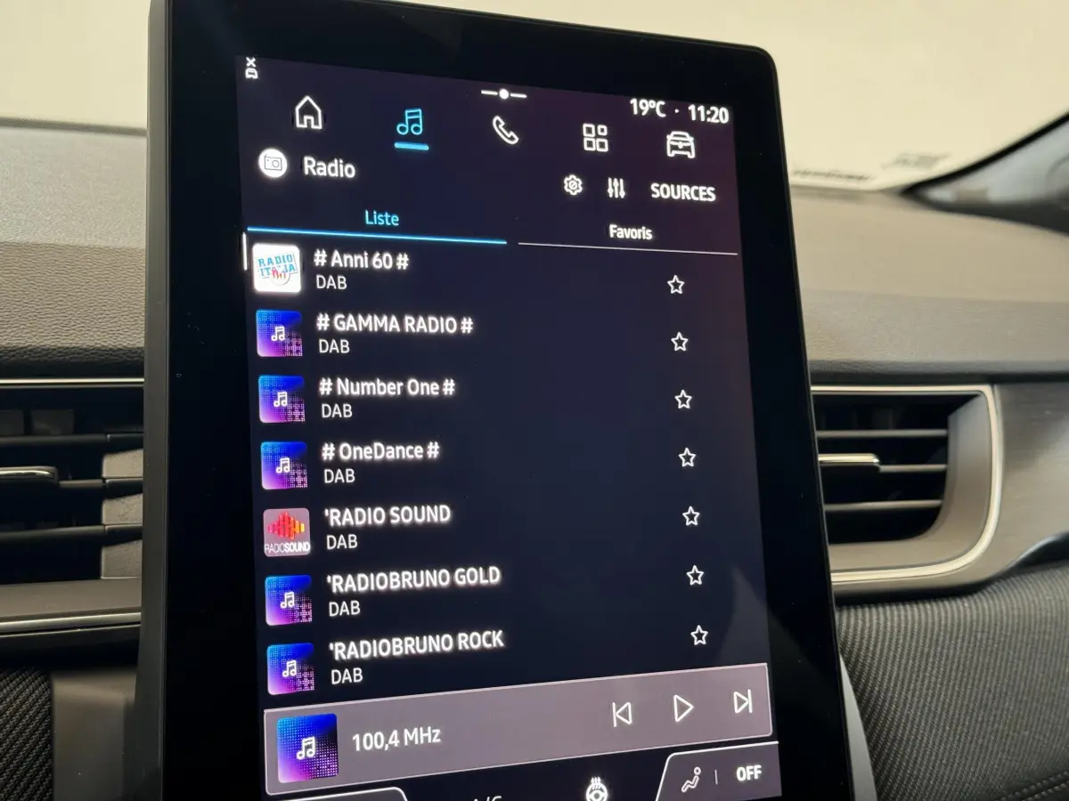 Écran tactile central du tableau de bord du Renault Captur blanc esprit Alpine E-Tech, affichant les stations radio DAB.
