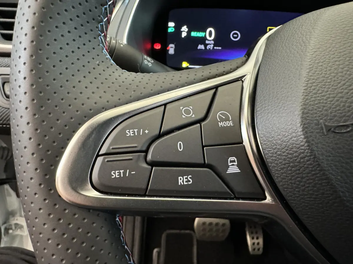 Gros plan sur les commandes gauche du volant cuir perforé du Renault Captur Esprit Alpine E-Tech blanc 2025.