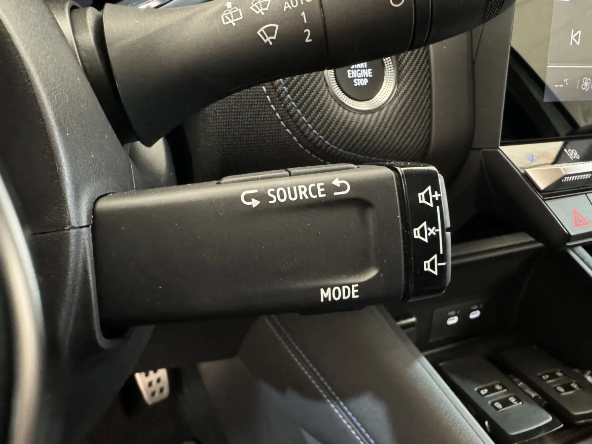 Gros plan sur la commande multimédia au volant du Renault Captur blanc esprit Alpine E-Tech 2025, intérieur noir.