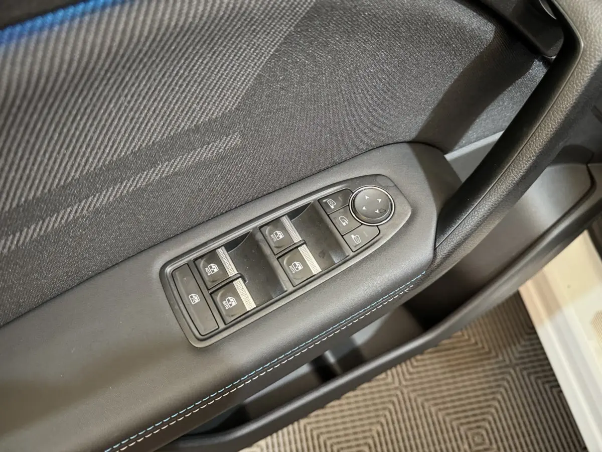 Gros plan sur la commande des vitres et rétroviseurs côté conducteur du Renault Captur blanc esprit Alpine E-Tech 2025.