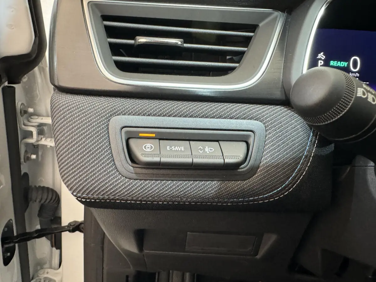 Gros plan sur les commandes à gauche du volant du Renault Captur blanc esprit Alpine E-Tech 2025, avec bouton E-SAVE allumé.