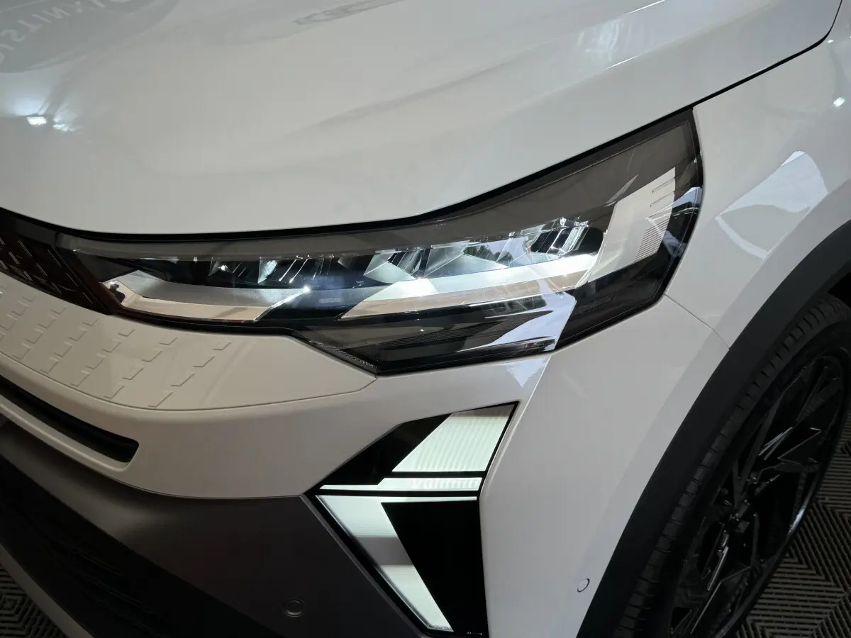 Gros plan sur le phare avant droit LED du Renault Captur blanc esprit Alpine E-Tech 2025 avec signature lumineuse distinctive.