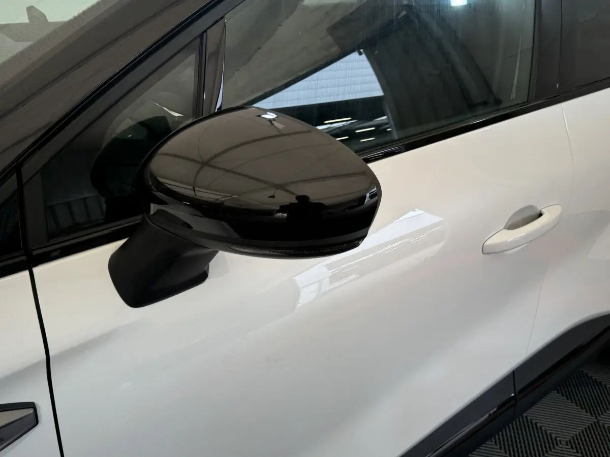 Rétroviseur noir en gros plan côté gauche sur la porte blanche d'un Renault Captur esprit Alpine E-Tech 2025.