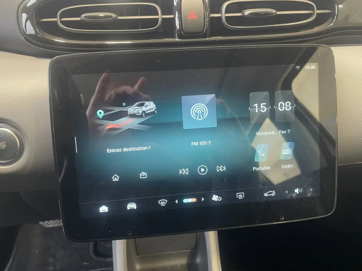 Écran tactile central du tableau de bord du Leapmotor T03 Luxury blanc, affichant navigation et radio.