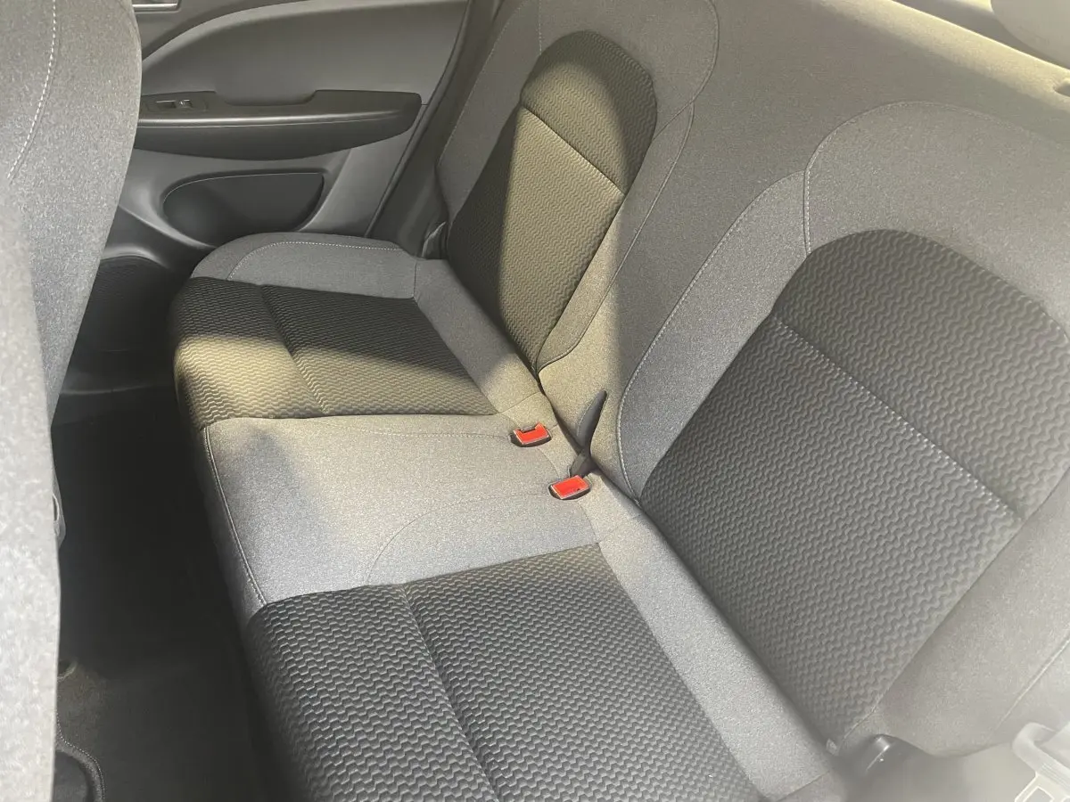 Vue rapprochée de la banquette arrière grise et noire du Leapmotor T03 Luxury 2025, montrant les ceintures rouges.