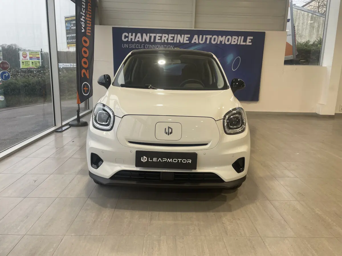 Vue de face du LEAPMOTOR T03 Luxury blanc électrique, avec phares LED et logo central sur fond lisse.