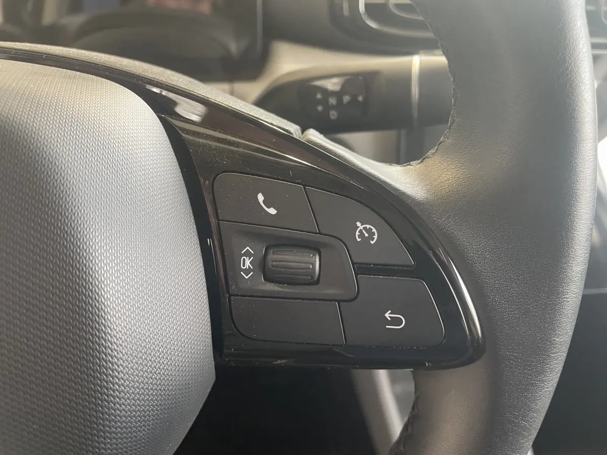 Gros plan sur le volant cuir noir du LEAPMOTOR T03 Luxury 2025, montrant les commandes multifonctions côté gauche.