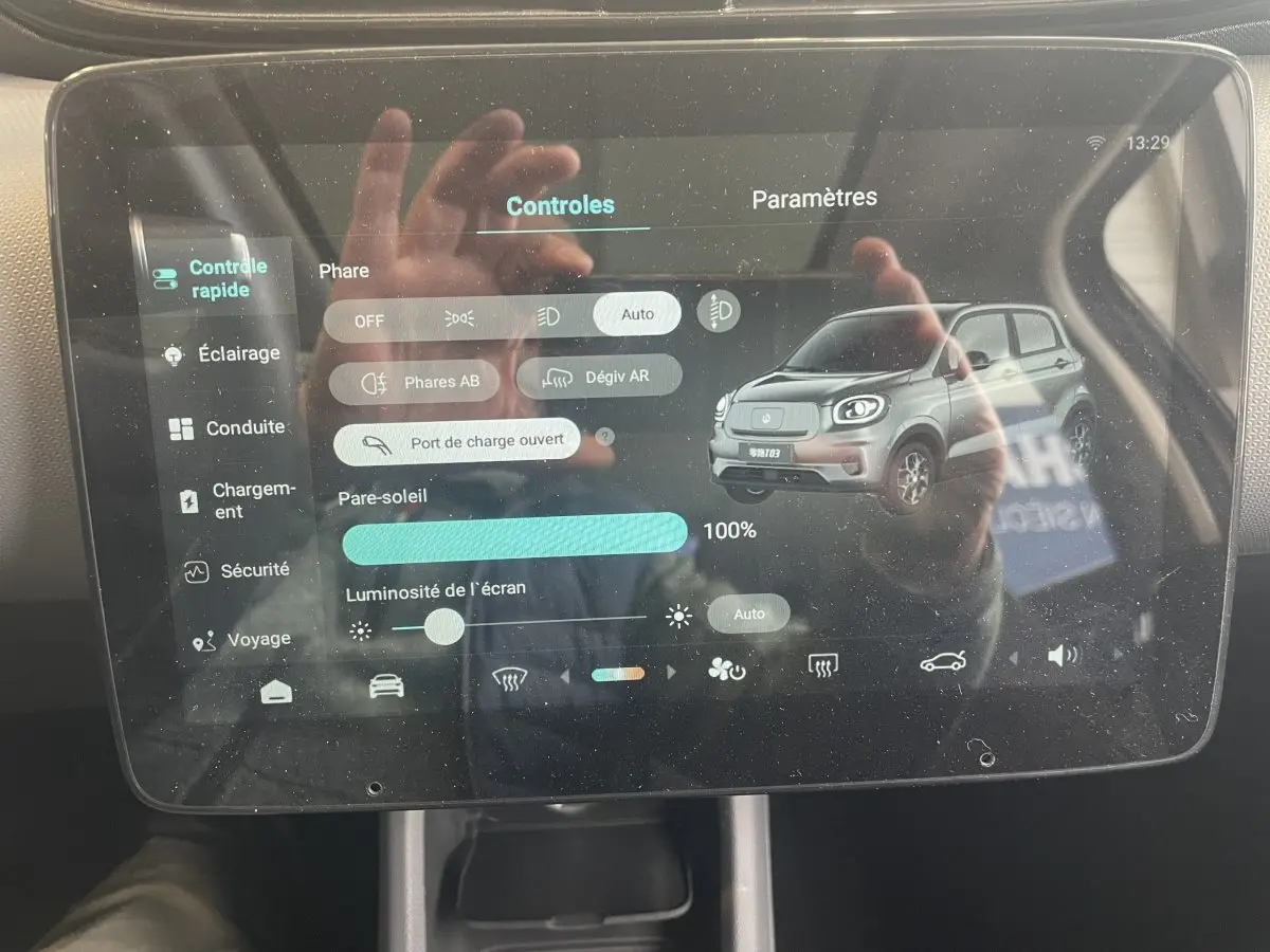 Écran tactile central affichant les réglages avec une image 3/4 avant du Leapmotor T03 blanc.