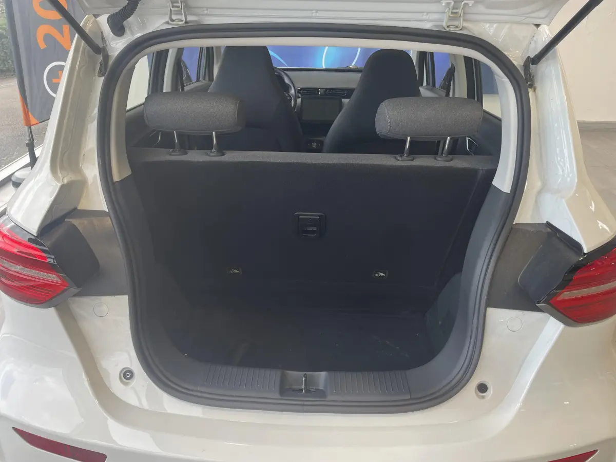 Vue arrière ouverte du coffre du LEAPMOTOR T03 Luxury blanc, montrant les sièges avant et l'intérieur épuré.