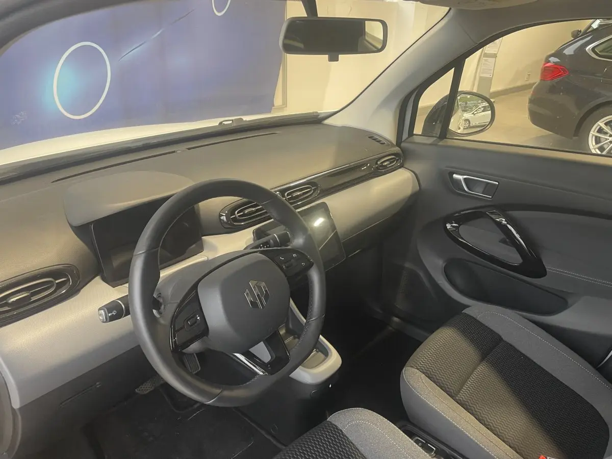 Vue intérieure côté conducteur du tableau de bord et volant cuir noir du LEAPMOTOR T03 Luxury blanc 2025.