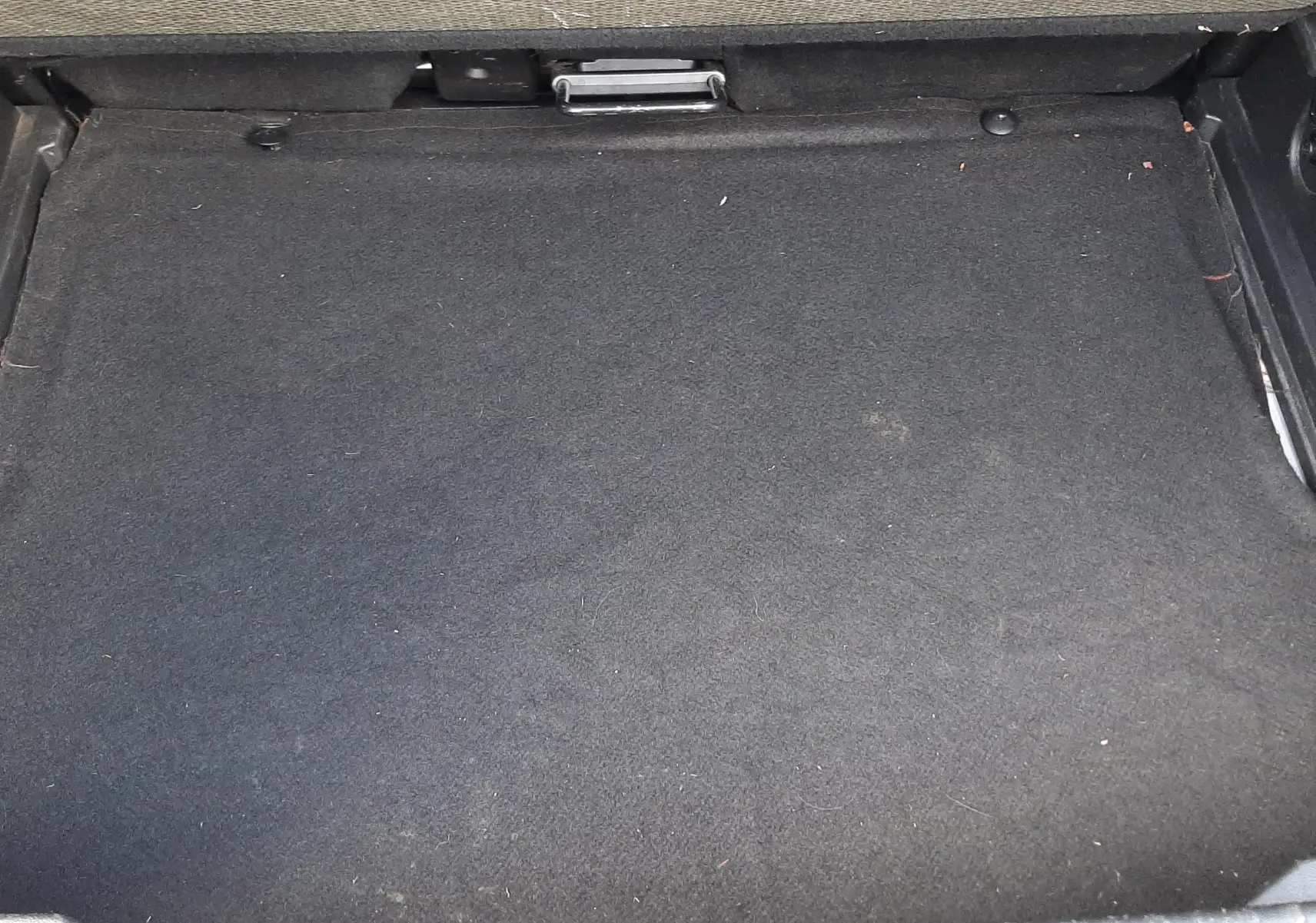 Espace de rangement sous le plancher de coffre du Renault Captur blanc toit noir, vue intérieure du compartiment vide.