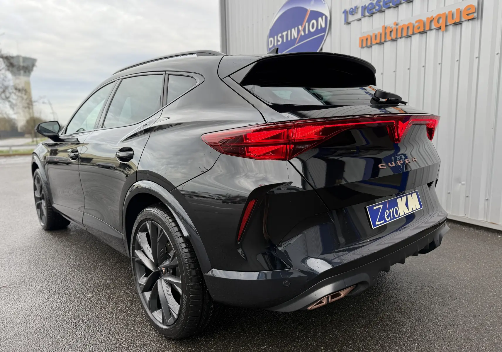 Vue 3/4 arrière droite du CUPRA Formentor noir minuit 2025 avec feux arrière LED et jantes noires biton.