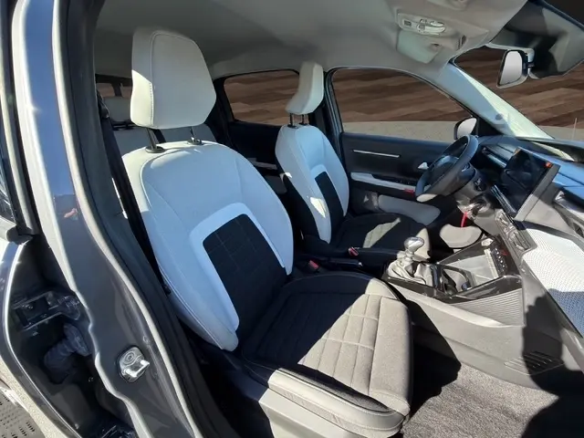 Intérieur avant de la Citroën C3 Turbo 100 BVM6 gris foncé, sièges bicolores et tableau de bord avec écran tactile.