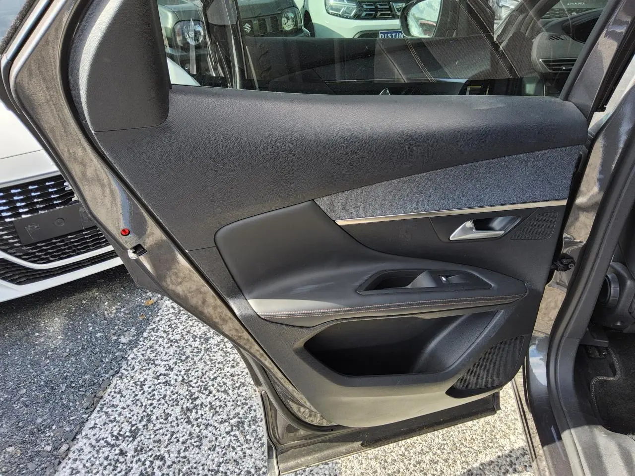 Gros plan sur la porte arrière gauche gris métallisé du Peugeot 3008 2017 avec garniture noire et insert tissu gris.