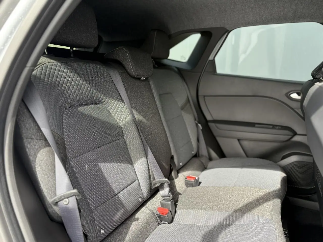 Banquette arrière grise vue côté gauche du Renault SYMBIOZ 2025, avec ceintures et appuie-têtes intégrés.
