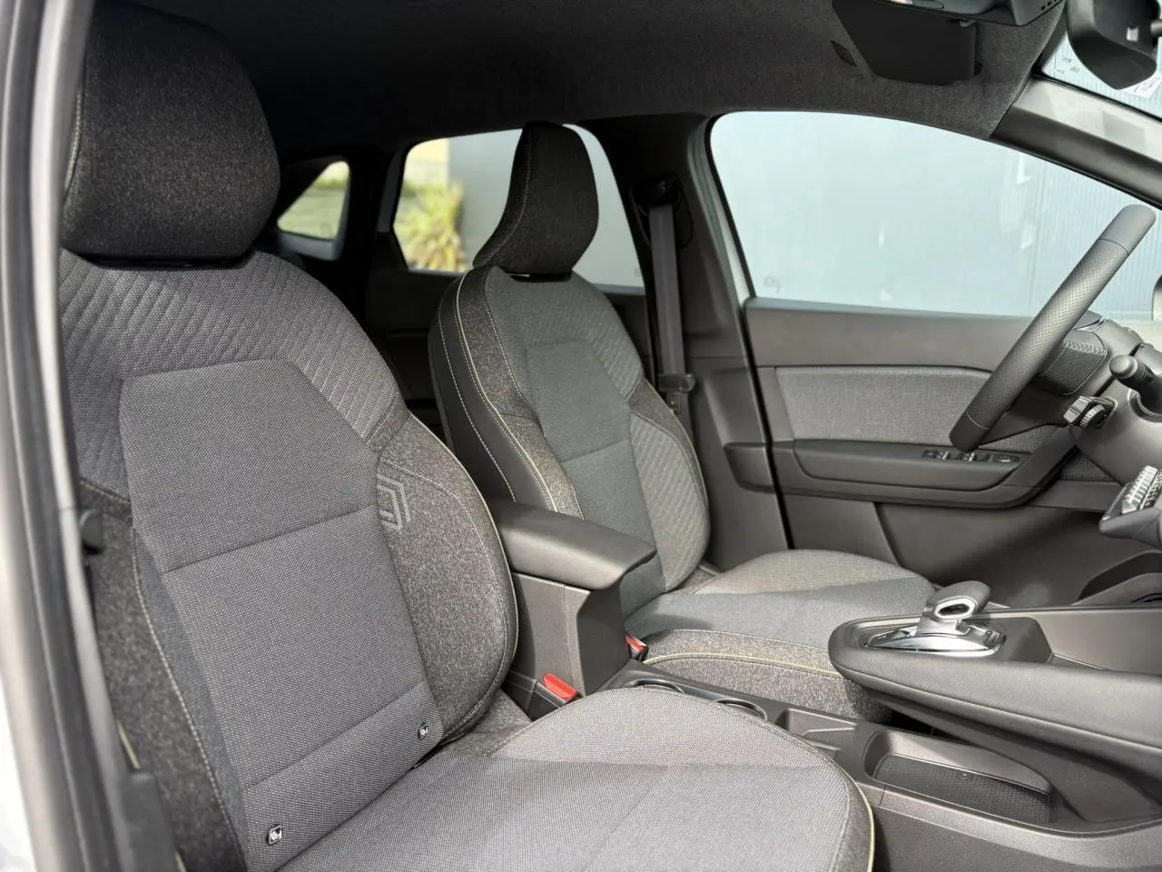 Intérieur de la Renault SYMBIOZ 2025, vue côté droit sur les sièges gris et la console centrale avec levier de boîte automatique.