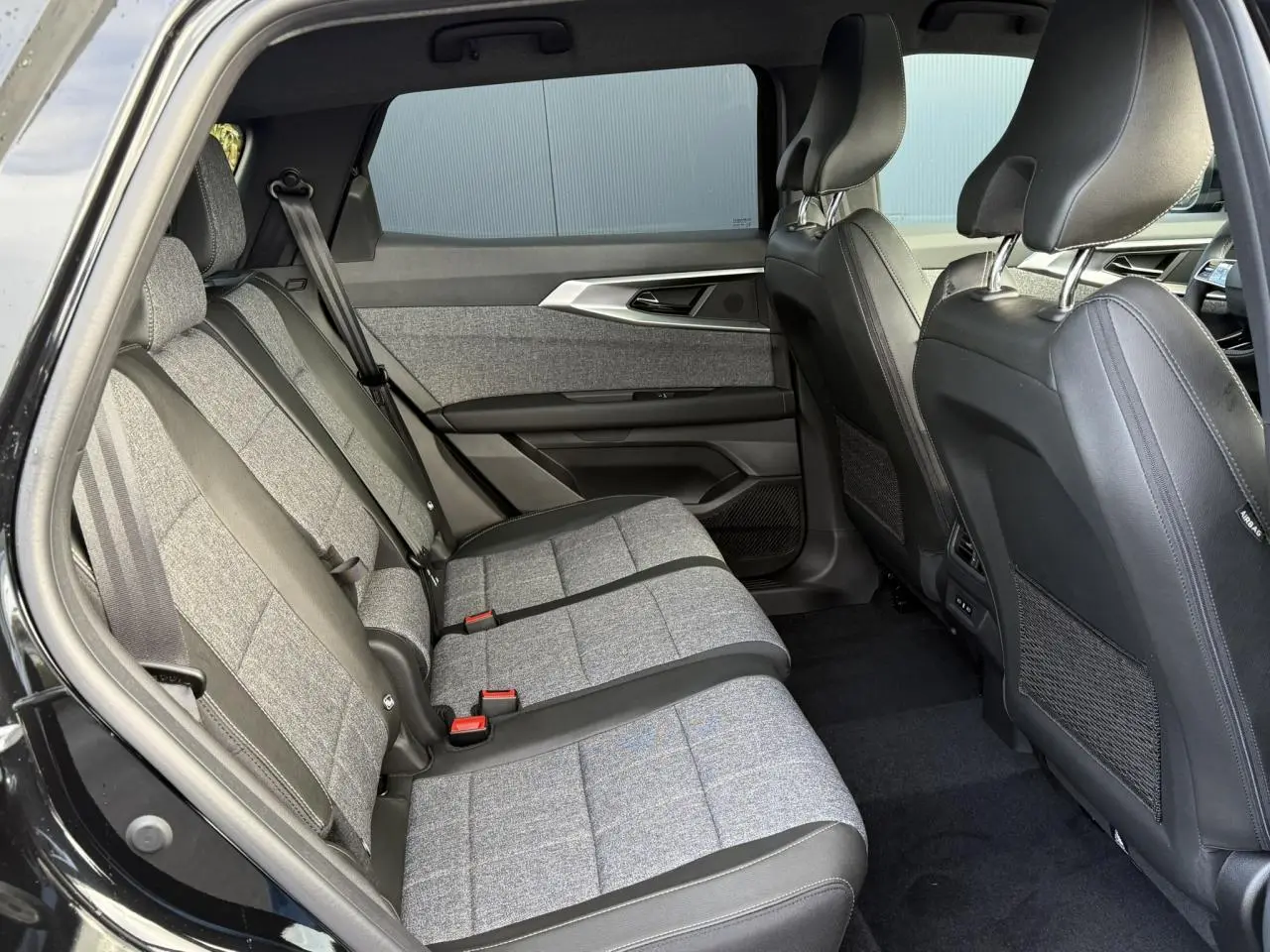 Vue intérieure côté gauche des sièges arrière gris tissu et cuir du Renault Espace VI noir étoilé 2025.