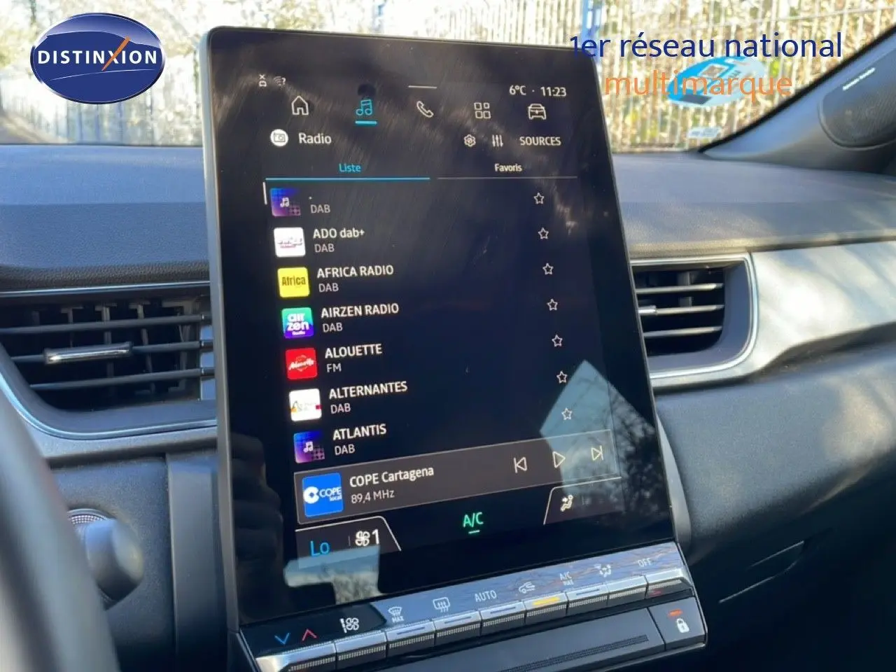 Vue intérieure du tableau de bord du Renault Captur 2025, écran tactile central affichant les stations radio, ambiance moderne.
