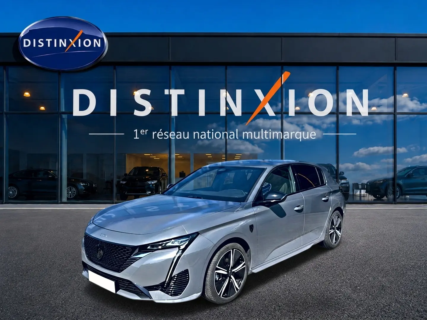 PEUGEOT 308 1.2 hybrid gris vue 3/4 avant droit, avec jantes alliage et calandre noire distinctive.
