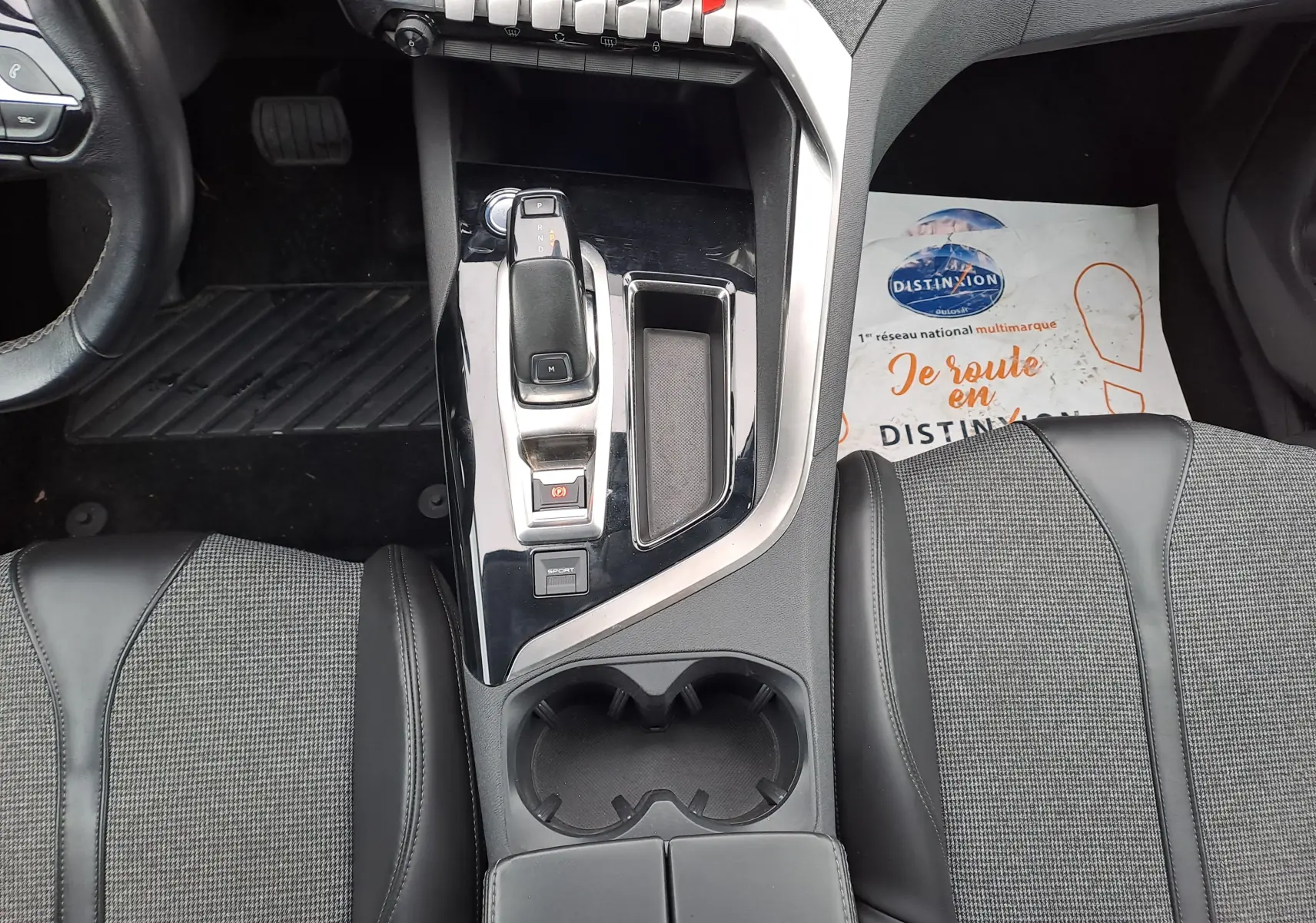 Vue intérieure centrée sur la console centrale noire brillante et le levier de vitesse automatique du Peugeot 3008 blanc de 2018.