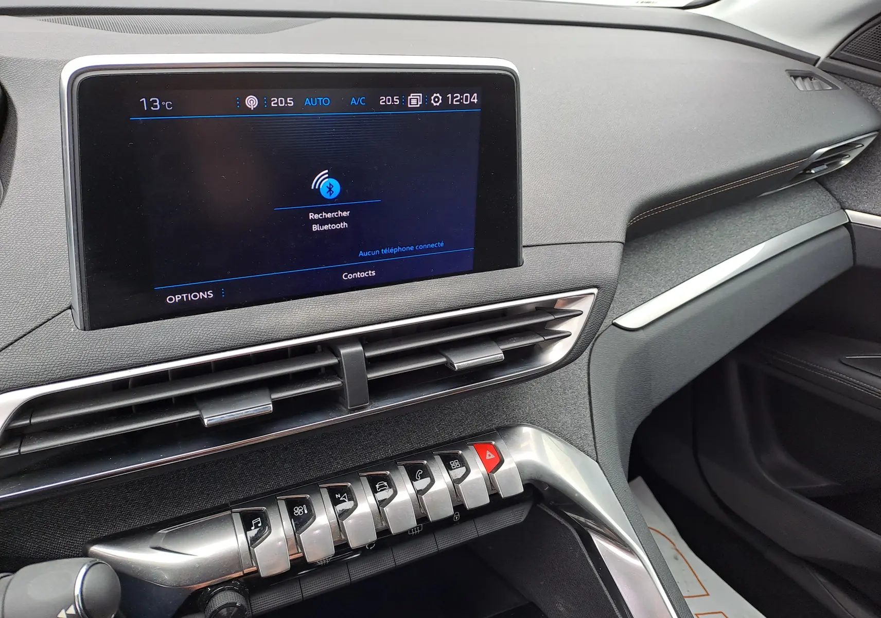 Vue rapprochée de la console centrale du Peugeot 3008 blanc, écran tactile et commandes métalliques visibles.