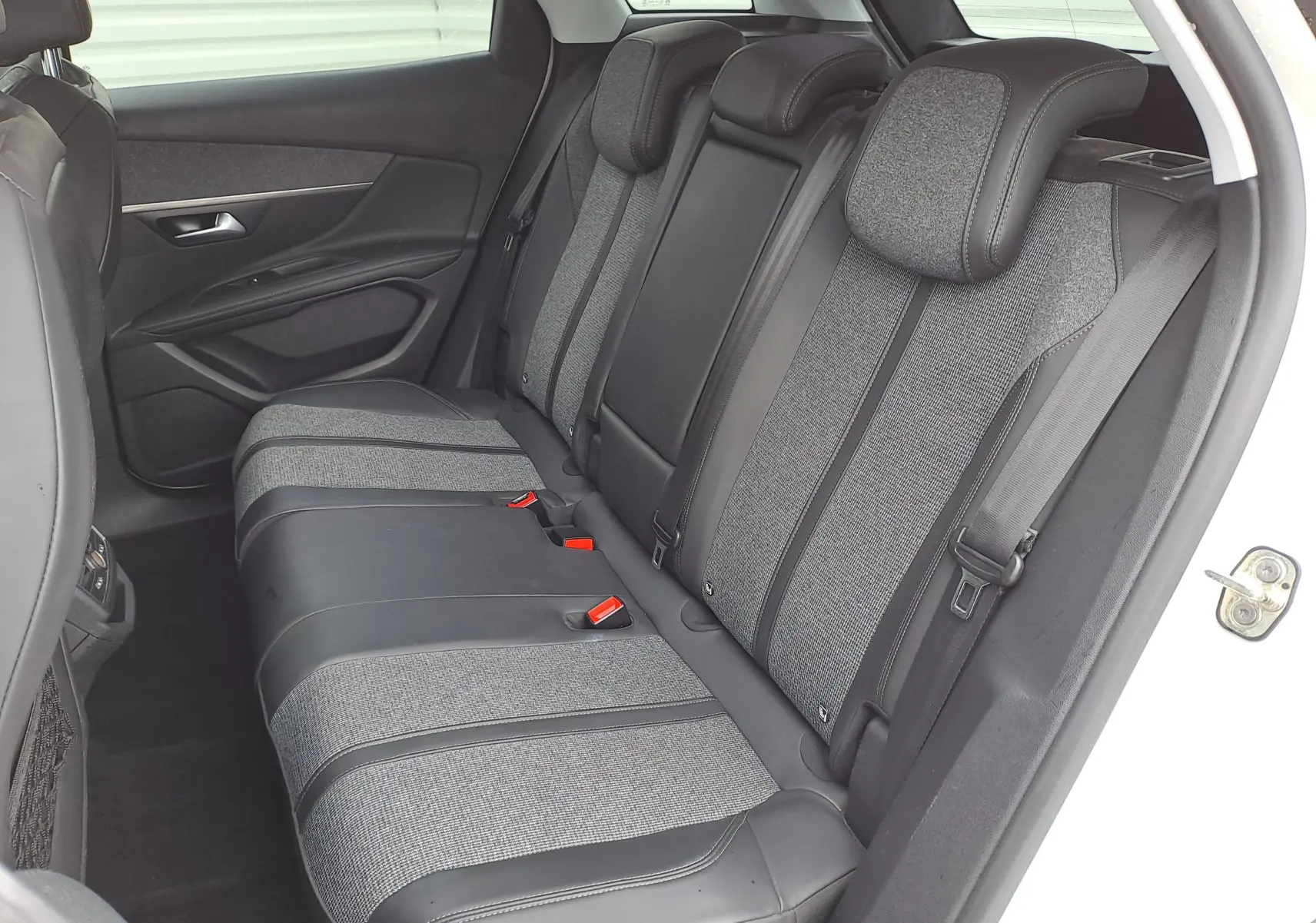 Vue intérieure côté droit des sièges arrière gris tissu et cuir du Peugeot 3008 blanc de 2018.