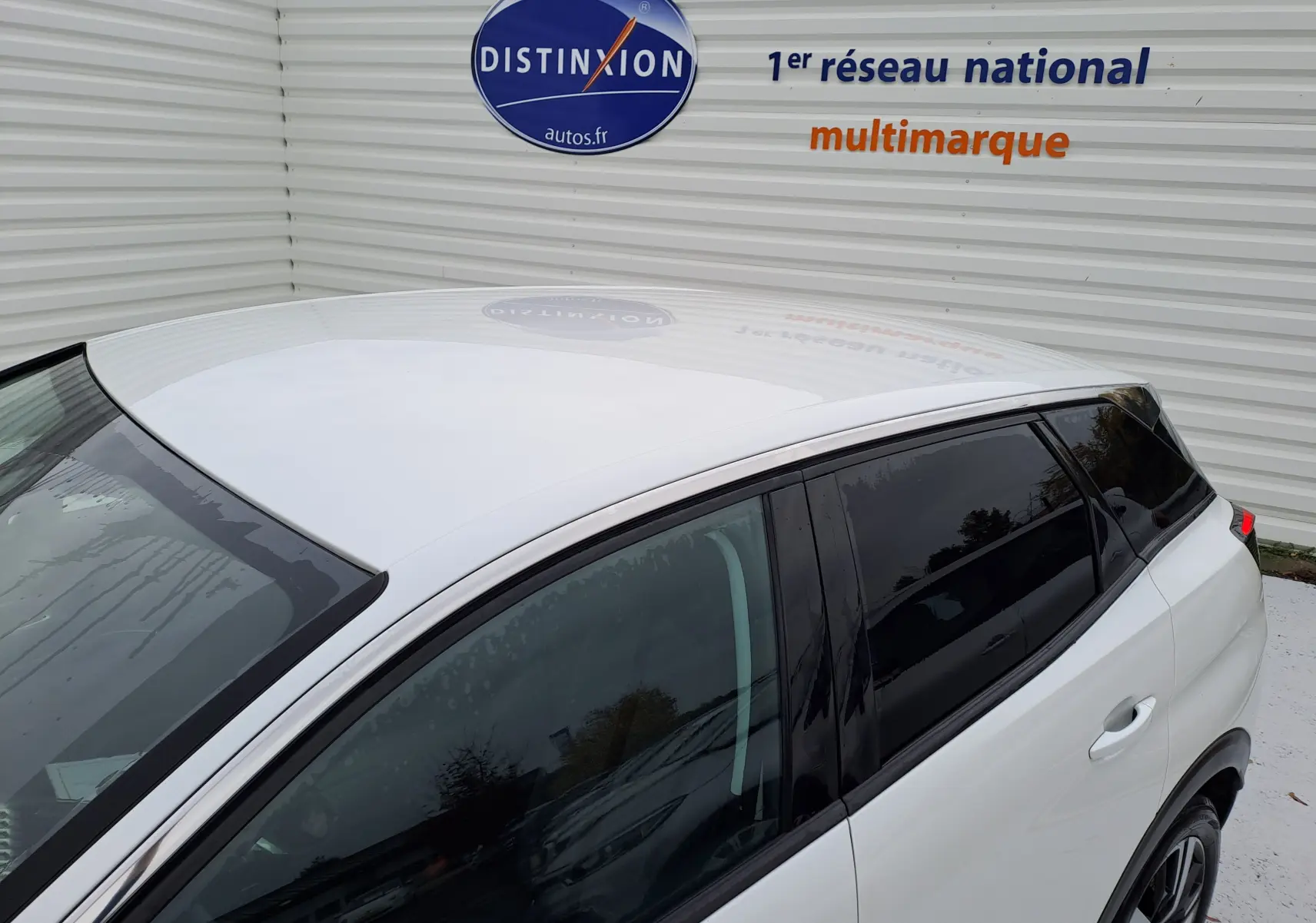 Vue de dessus et côté gauche d'un Peugeot 3008 blanc 2018 avec vitres teintées et jantes alliage.