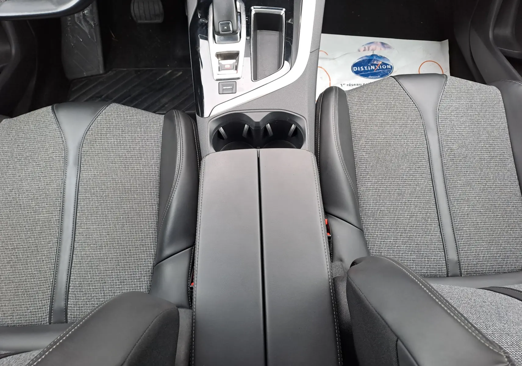 Vue plongeante sur la console centrale et les sièges avant gris et noir du Peugeot 3008 blanc 2018.