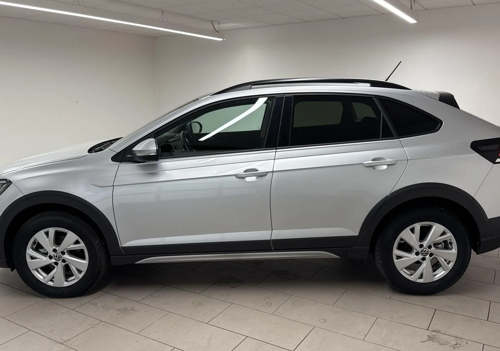 Profil côté gauche d'un Volkswagen Taigo gris cendré 2024 avec jantes alliage et toit noir contrasté.