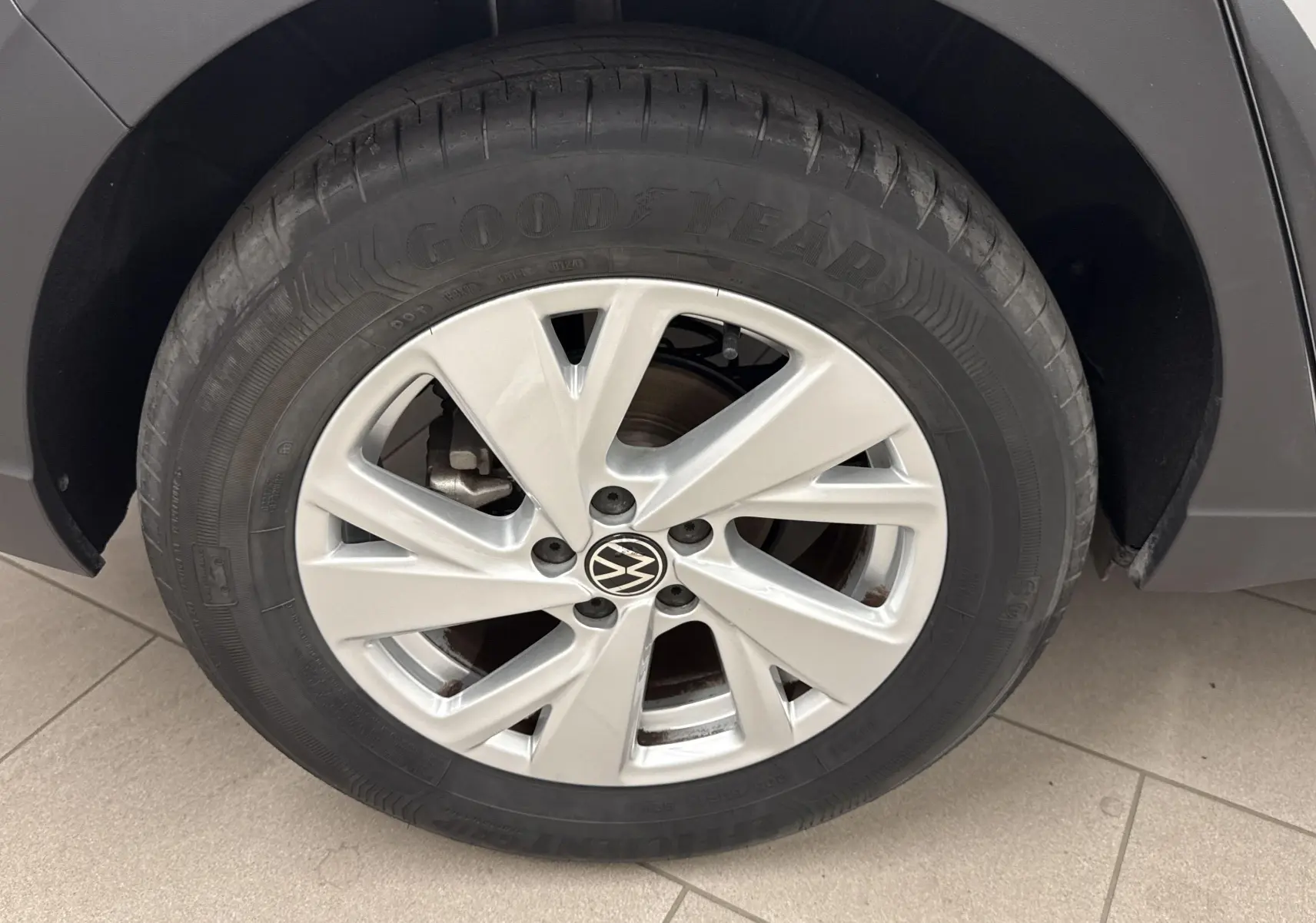 Gros plan sur la roue avant gauche du Volkswagen Taigo gris cendré montrant la jante alliage et le pneu Goodyear.