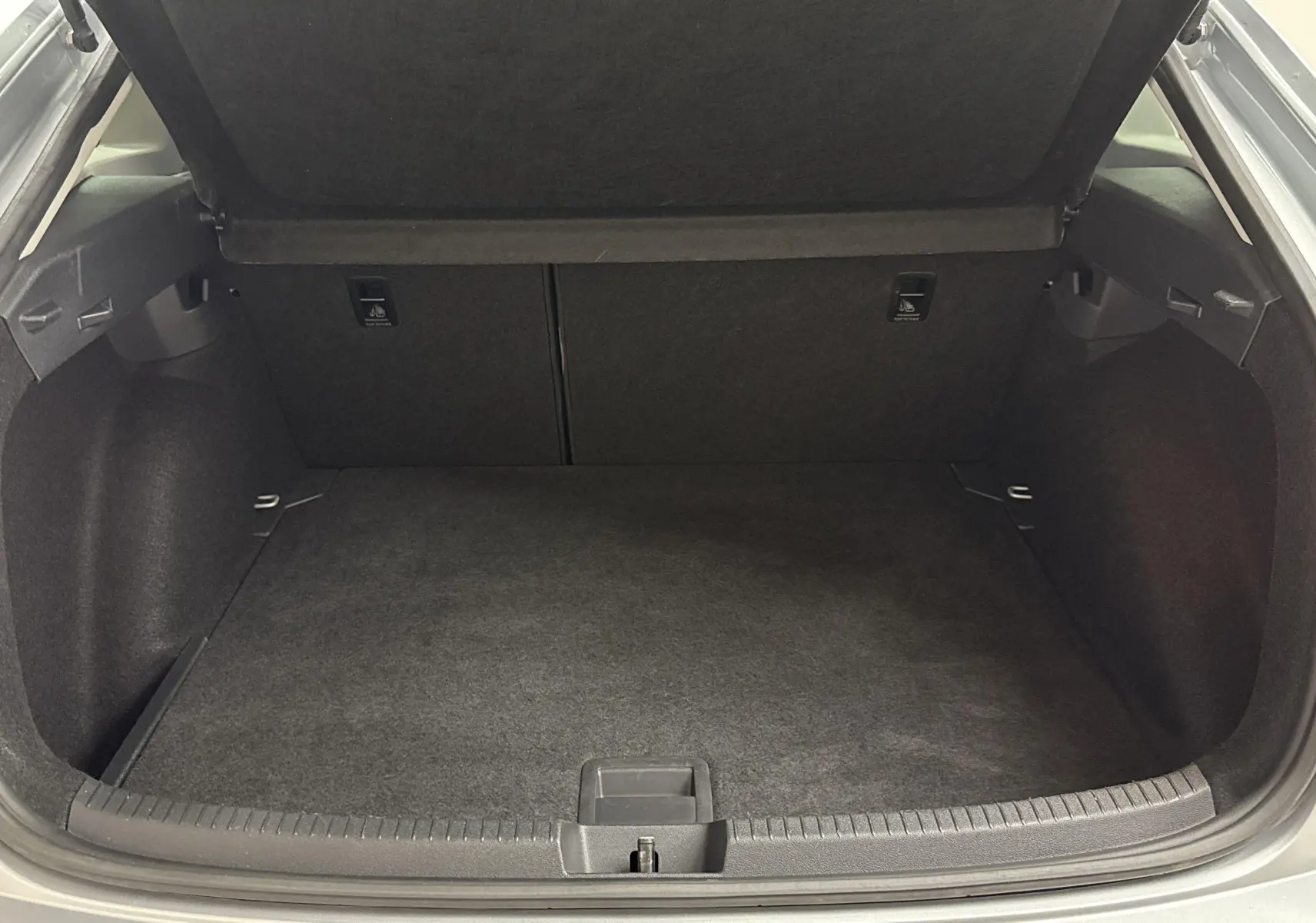 Coffre ouvert du Volkswagen Taigo gris cendré 2024, vue intérieure montrant un espace de chargement propre et spacieux.