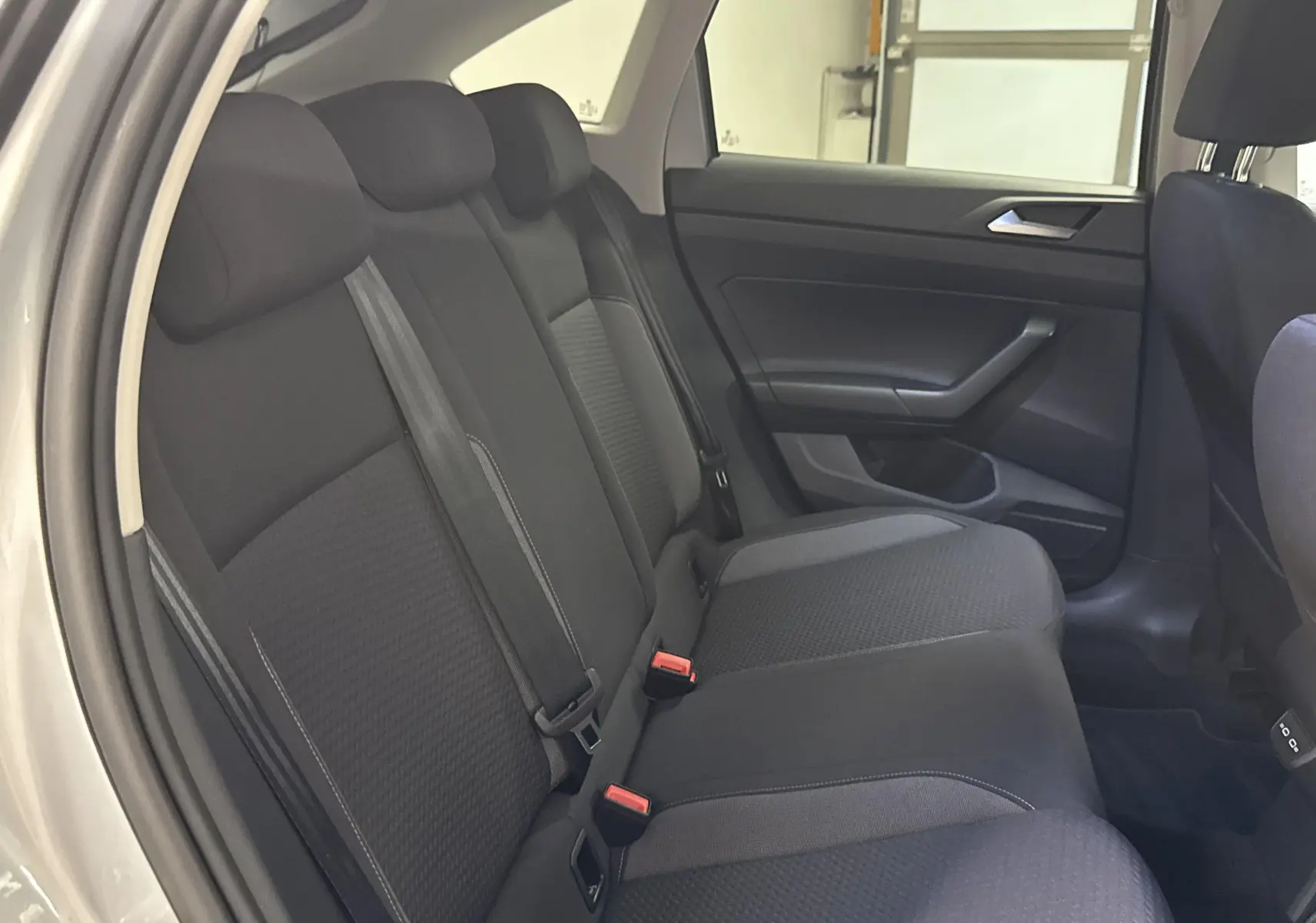 Vue intérieure côté droit sur la banquette arrière noire du Volkswagen Taigo gris cendré 2024 finition Life.
