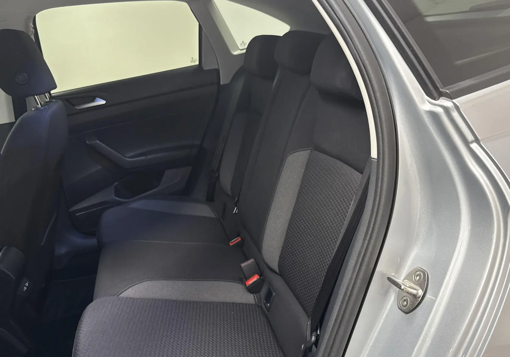 Vue intérieure du siège arrière côté droit du Volkswagen Taigo gris cendré 2024 avec habillage tissu bicolore.