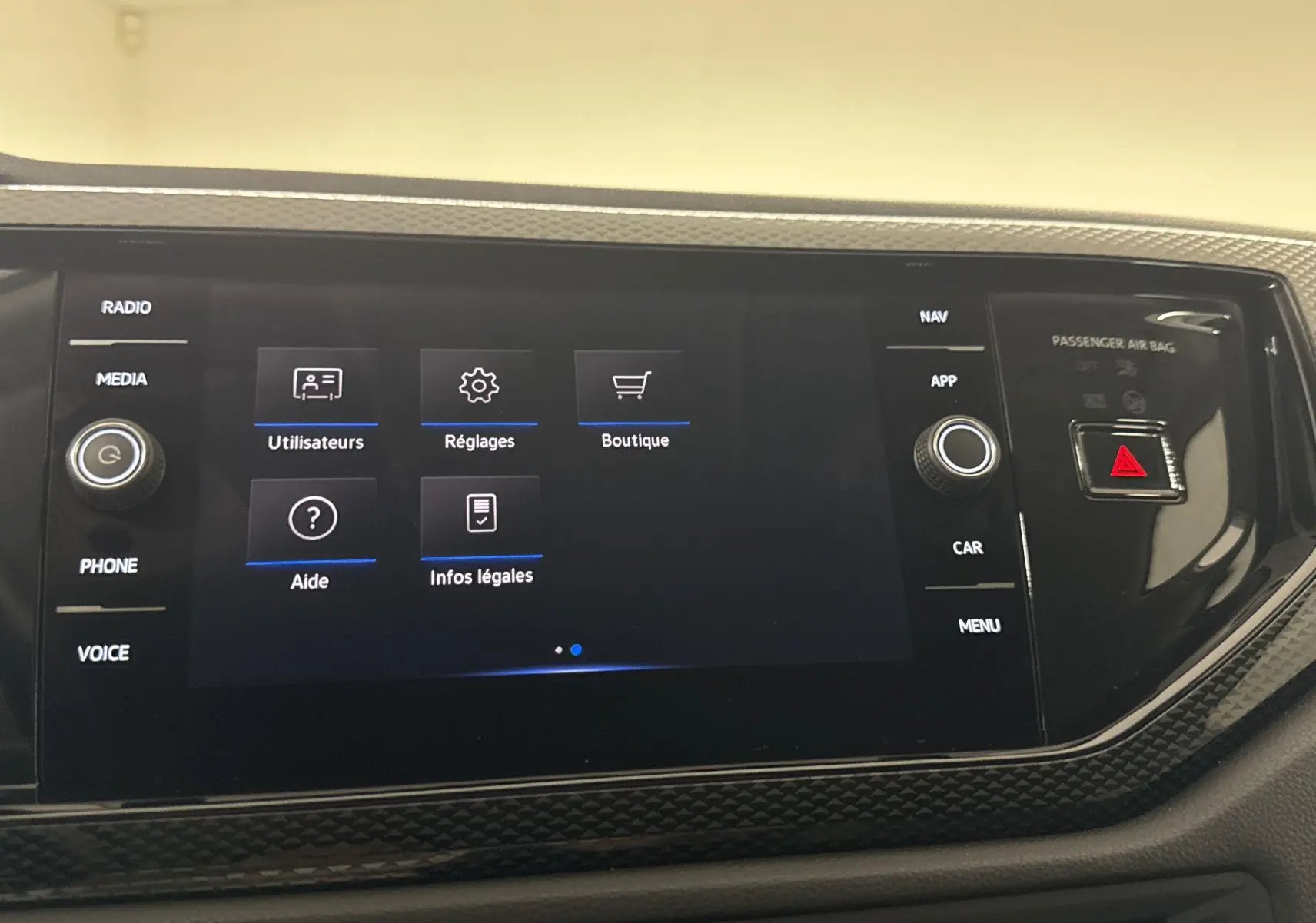 Écran tactile central du Volkswagen Taigo 2024 affichant le menu réglages, entouré de boutons et finition carbone.