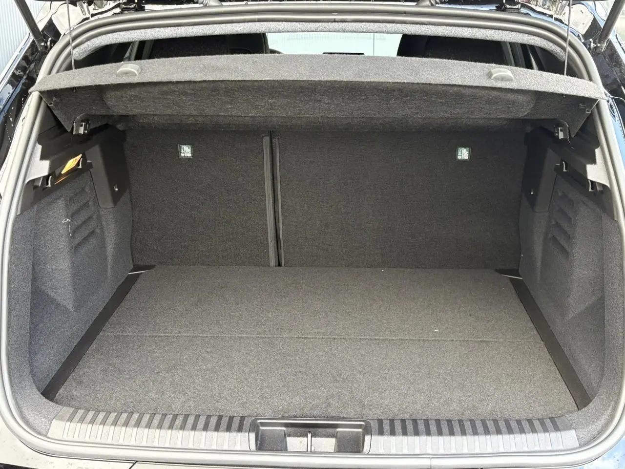 Coffre ouvert d'un Renault SYMBIOZ noir étoile, vue intérieure montrant l'espace de chargement vide et la moquette grise.